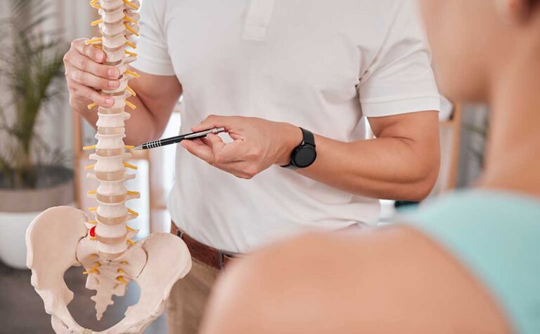 Athlete receiving a careful back adjustment in a bright clinical treatment room
