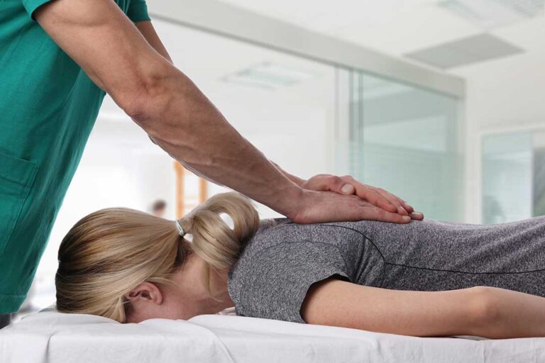 A person gently stretching their neck at home while seated on a comfortable couch.